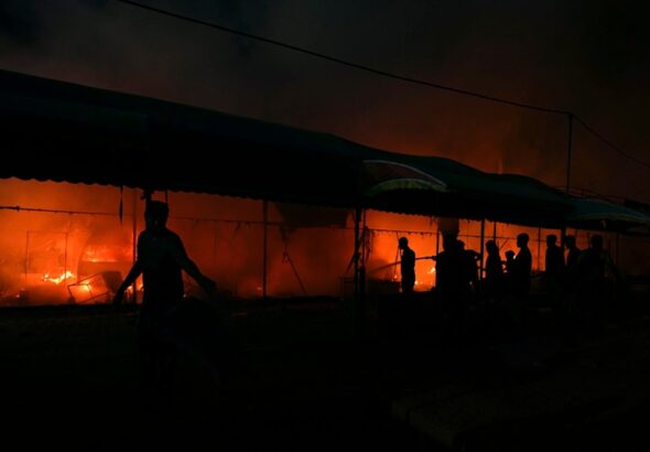 Palestinians try to extinguish a fire caused by Israeli airstrikes on tents in the courtyard of Al-Aqsa Martyrs Hospital, Deir al-Balah, central Gaza Strip, October 14, 2024. Photo: AP.