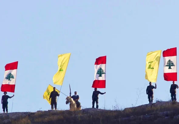 Resistance fighters stand with flags of Hezbollah and Lebanon. Photo: Social media.
