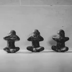 Three small figurines sitting in a row. Photo: Dendy Darma Satyazi/Unsplash.