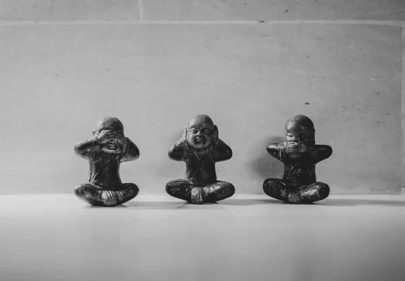 Three small figurines sitting in a row. Photo: Dendy Darma Satyazi/Unsplash.