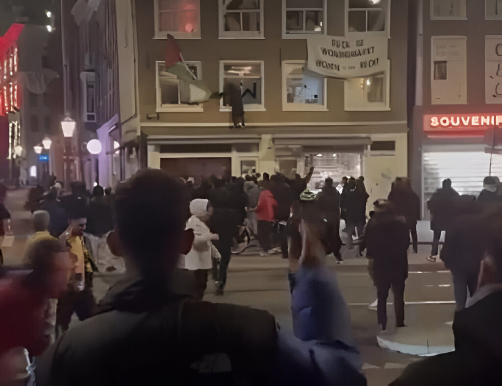Israeli hooligans tearing down a Palestinian flag hanging on an Amsterdam building in solidarity with the Palestinian people being massacred in Gaza by the occupation entity of "Israel." Photo: X/@hel7endy.
