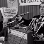 Sol Goldstein, spokesman for a group of Jewish organizations, holds up a German language newspaper with headlines questioning the validity of the Holocaust, at a news conference in Chicago, June 14, 1978. Photo: AP.