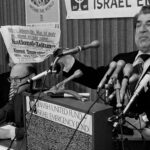 Sol Goldstein, spokesman for a group of Jewish organizations, holds up a German language newspaper with headlines questioning the validity of the Holocaust, at a news conference in Chicago, June 14, 1978. Photo: AP.