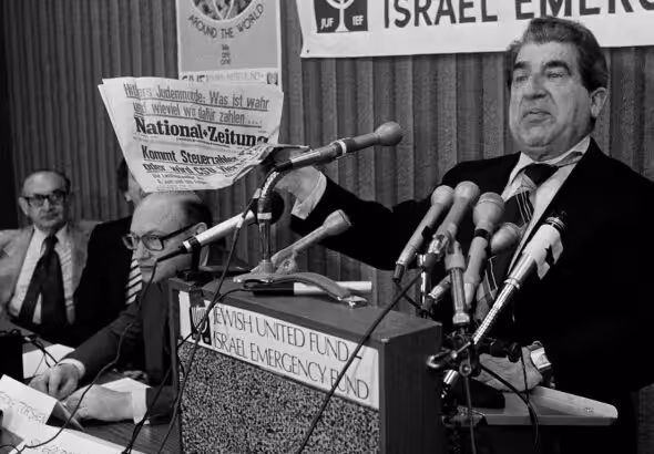 Sol Goldstein, spokesman for a group of Jewish organizations, holds up a German language newspaper with headlines questioning the validity of the Holocaust, at a news conference in Chicago, June 14, 1978. Photo: AP.
