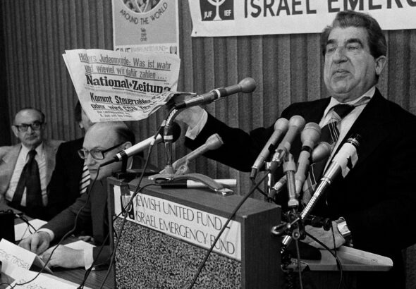 Sol Goldstein, spokesman for a group of Jewish organizations, holds up a German language newspaper with headlines questioning the validity of the Holocaust, at a news conference in Chicago, June 14, 1978. Photo: AP.