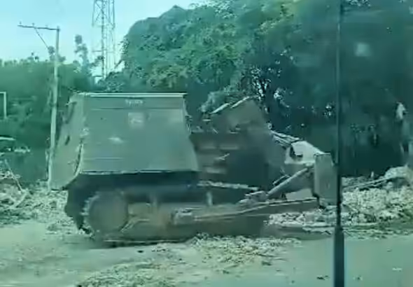 An armored bulldozer known as “Satan” destroying houses in Lower Delmas on Nov. 24. Photo: Haïti Liberté.