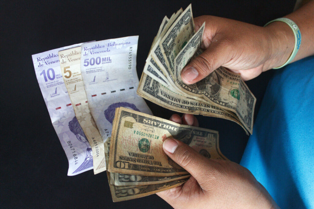 A person holds Venezuelan bolívars and US dollar bills. File photo.