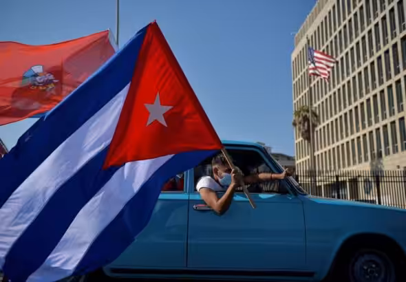Cubans drive past the US embassy during a rally calling for the end of the US blockade. Photo: Yamil Lage/AFP.
