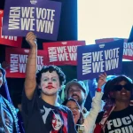 Attendees hold up signs during a campaign rally with Democratic presidential nominee and US Vice President Kamala Harris in Las Vegas, Nevada, October 31, 2024. Photo: Ethan Miller/Getty Images/AFP.