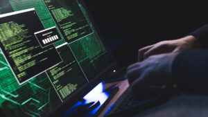 Featured image: A person types on a keyboard in front of a monitor with several open command windows.