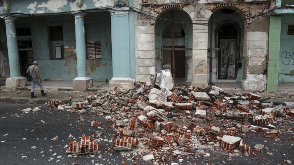 Debris from a building damaged by Hurricane Rafael covers the street in Havana, Cuba. Photo: Ariel Ley/AP.