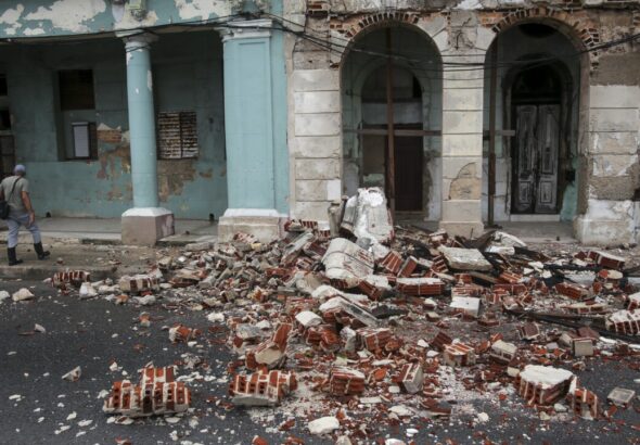 Debris from a building damaged by Hurricane Rafael covers the street in Havana, Cuba. Photo: Ariel Ley/AP.