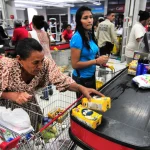 Venezuelans buy food products in a supermarket. File photo.