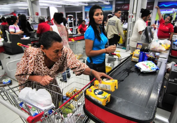 Venezuelans buy food products in a supermarket. File photo.