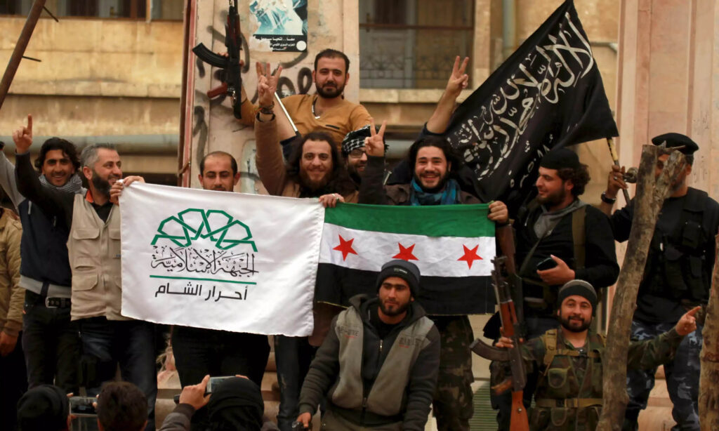 NATO-backed fighters in Idlib wave flags representing Ahrar al-Sham (left), Free Syrian Army (center), and al-Nusra Front (right) in March 2015. Photo: Reuters/Ammar Abdullah.