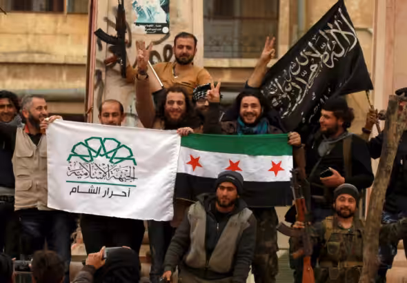 NATO-backed fighters in Idlib wave flags representing Ahrar al-Sham (left), Free Syrian Army (center), and al-Nusra Front (right) in March 2015. Photo: Reuters/Ammar Abdullah.