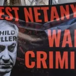 Protesters with a banner calling for Zionist prime minister Benjamin Netanyahu to be arrested march through central London to call for a permanent ceasefire in Gaza on November 25, 2023. Photo: Mark Kerrison/Common Dreams/Getty Images.