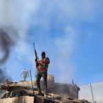 A Palestinian resistance fighter stands atop a burning "Israeli" tank on October 7, 2023. Photo: Hani Alshaer/AA/Getty Images.