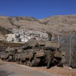Israeli occupation armored forces take position outside the occupied village of Majdal Shams near the buffer zone that separates the occupied Golan Heights from the rest of Syria, December 9, 2024. Photo: AFP.