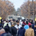 Lebanese people fly Hezbollah flags near an Israeli military vehicle in Borj al-Molouk, after crossing an Israeli roadblock on the road leading to Kfar Kila in southern Lebanon, January 26, 2025. Photo: AFP.