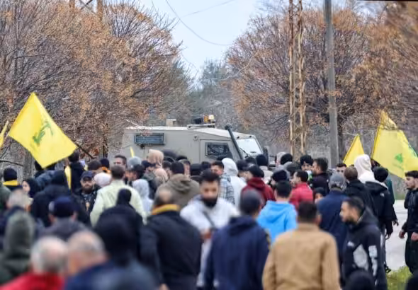 Lebanese people fly Hezbollah flags near an Israeli military vehicle in Borj al-Molouk, after crossing an Israeli roadblock on the road leading to Kfar Kila in southern Lebanon, January 26, 2025. Photo: AFP.