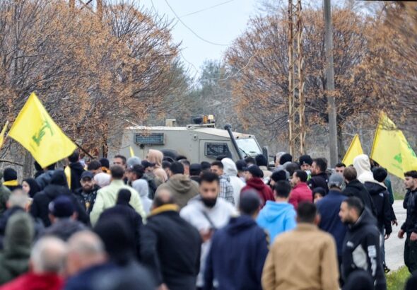 Lebanese people fly Hezbollah flags near an Israeli military vehicle in Borj al-Molouk, after crossing an Israeli roadblock on the road leading to Kfar Kila in southern Lebanon, January 26, 2025. Photo: AFP.