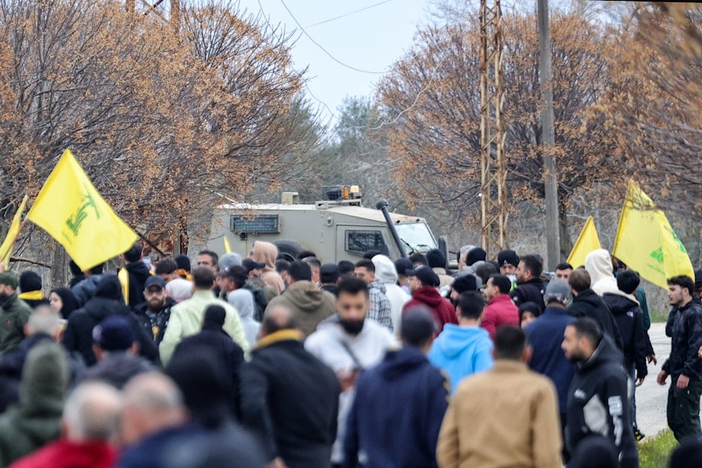Lebanese people fly Hezbollah flags near an Israeli military vehicle in Borj al-Molouk, after crossing an Israeli roadblock on the road leading to Kfar Kila in southern Lebanon, January 26, 2025. Photo: AFP.