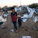 Palestinian children walk amid scattered debris in a tent camp in Khan Younis, southern Gaza Strip, after an overnight Israeli airstrike, January 2, 2025. Photo: AFP.