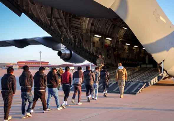 Chained migrants taken into a US military plane. Photo: X/@PressSec.