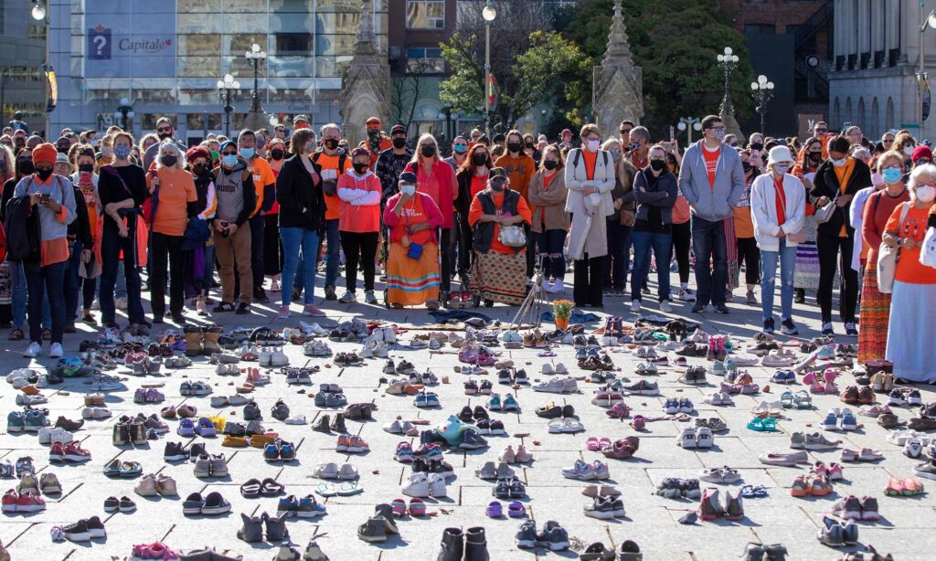 People stand around shoes that honor all the missing indigenous children during the first National Day for Truth and Reconciliation, on Parliament Hill in Ottawa, Canada, on September 30, 2021. Photo: VCG.