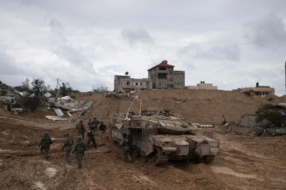 IOF soldiers walk by a tank during the ground invasion of the Gaza Strip in Khan Younis on Saturday, January 27, 2024. Photo: AP.