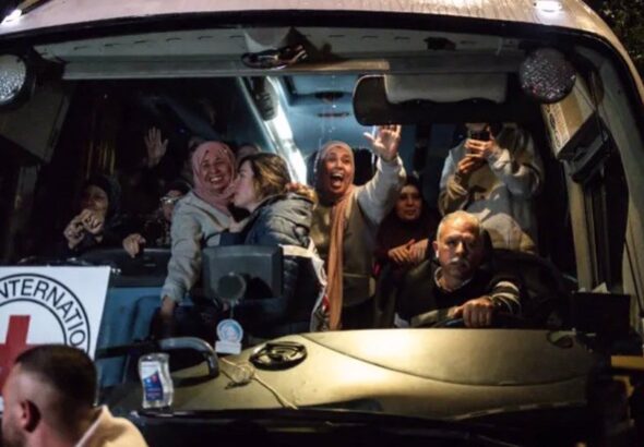 Palestinians freed from Israel’s Ofer military prison wave to the crowd from an International Committee of the Red Cross (ICRC) bus as they arrive in Beitunia, in the occupied West Bank on Monday morning. Photo: AFP.