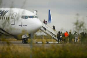 Migrants board a plane bound to southern Mexico as part of a repatriation flight to their countries, at the Piedras Negras International Airport, in Piedras Negras, Coahuila state, Mexico, December 23, 2023. Photo: Reuters/José Luis González.