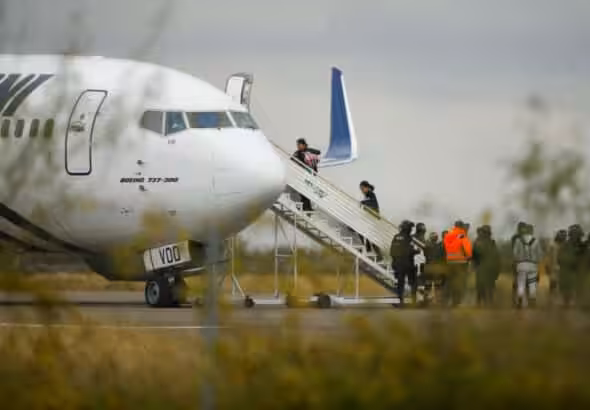 Migrants board a plane bound to southern Mexico as part of a repatriation flight to their countries, at the Piedras Negras International Airport, in Piedras Negras, Coahuila state, Mexico, December 23, 2023. Photo: Reuters/José Luis González.