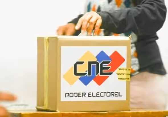 A Venezuelan voter deposits a ballot in a box at a polling center. File photo.