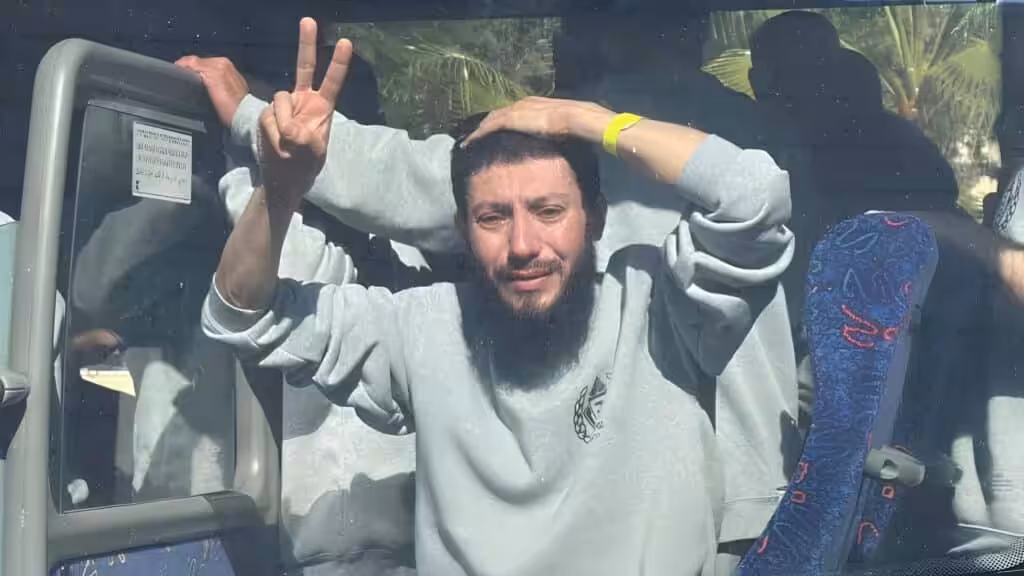 Palestinian prisoner Reza Ubaid, released from Israeli prison as part of the Gaza ceasefire deal, raises the victory sign as he steps of from the bus carrying freed prisoners, in Khan Younis, Gaza, February 1, 2025. Photo: Anadolu Agency.