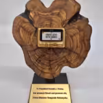 Benjamin Netanyahu's gift to Donald Trump (from one settler to another): a gaudy golden pager mounted on a slice of felled ancient olive tree; Feb 6, 2025. Photo: BBC.