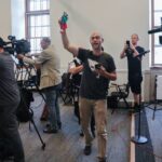 Yves Engler waves a Palestinian flag at Montreal Mayor Valérie Plante's press conference at Montreal city hall, July 5, 2024, protesting the police repression against a pro-Palestine encampment in Victoria Square. Photo: John Kenney/The Montreal Gazette.