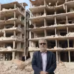 Dan Kovalik in front of the ruins of a buildings. Photo: Dan Kovalik/Covert Action Magazine.