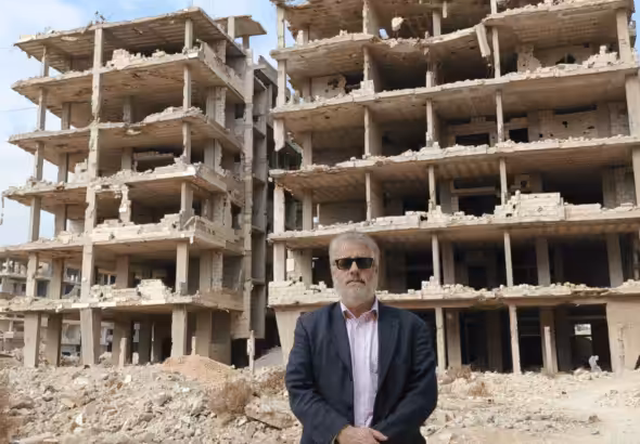 Dan Kovalik in front of the ruins of a buildings. Photo: Dan Kovalik/Covert Action Magazine.