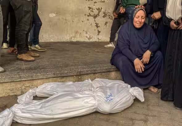 Mourners stand near the bodies of Palestinians killed in 'Israeli' strikes, ahead of a ceasefire set to take effect on Sunday (January 19), in Gaza City January 16, 2025. Photo: Hadi Daoud /Zuma Images.