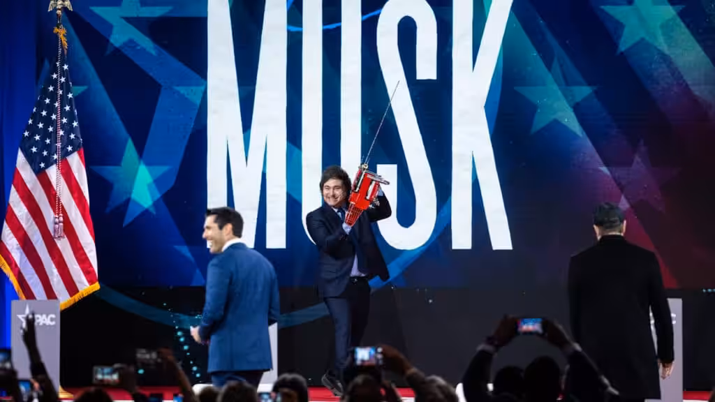 President of Argentina Javier Milei arrives on stage with a custom chainsaw before Elon Musk and Nesmax Host Rob Schmitt before speak, during day 1 of the 2025 Conservative Political Action Conference, February 20, 2025. Photo: Graeme Sloan/AP.