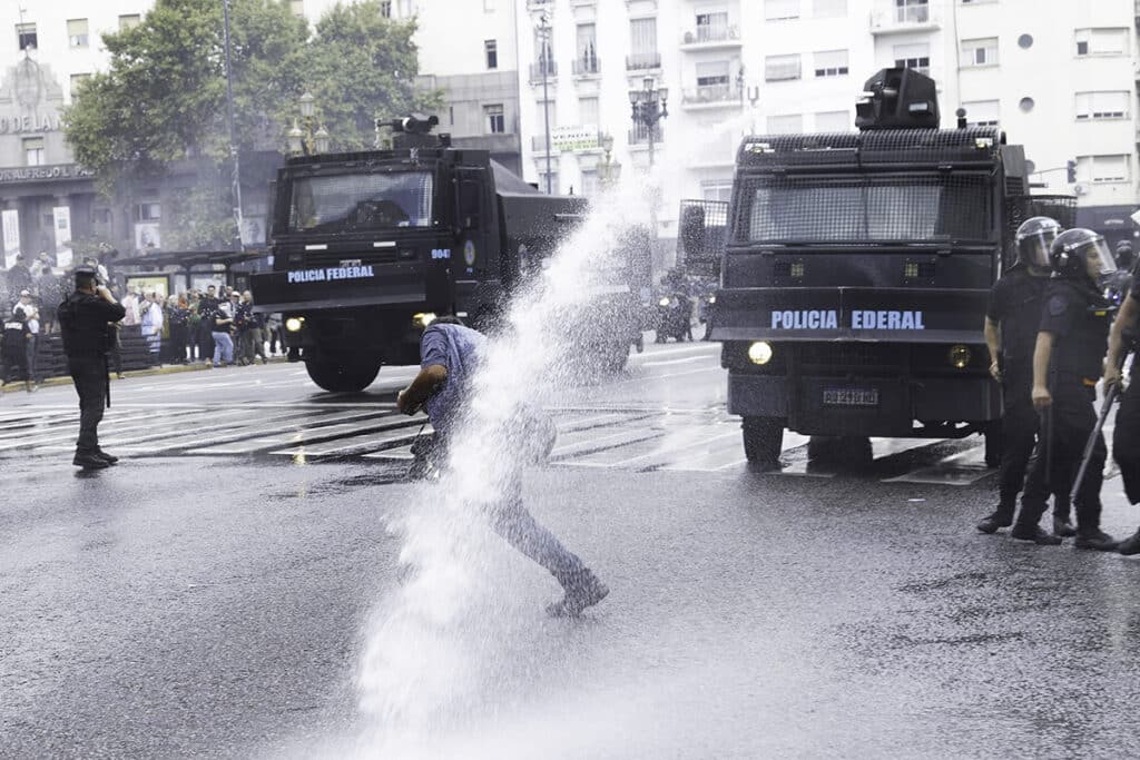 A demonstrator being hit by a water canon jet in the National Congress area, Buenos Aires, Argentina March 12, 2025. Photo: Damián Dopacio.