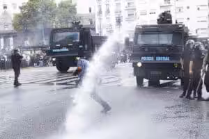 A demonstrator being hit by a water canon jet in the National Congress area, Buenos Aires, Argentina March 12, 2025. Photo: Damián Dopacio.