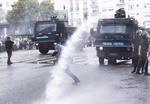 A demonstrator being hit by a water canon jet in the National Congress area, Buenos Aires, Argentina March 12, 2025. Photo: Damián Dopacio.