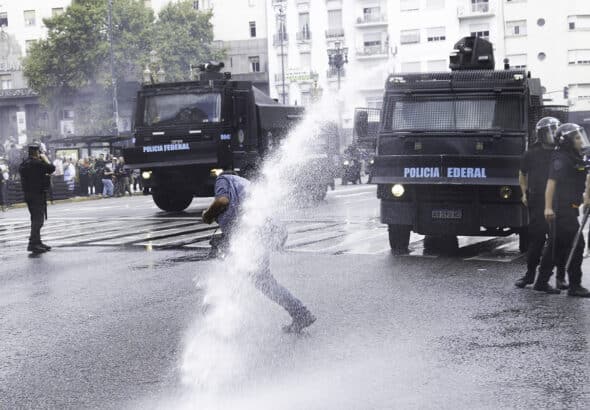 A demonstrator being hit by a water canon jet in the National Congress area, Buenos Aires, Argentina March 12, 2025. Photo: Damián Dopacio.