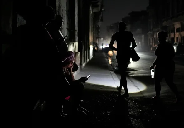 Havana residents walk through a street amid the blackout. Ramón Espinosa/AP.