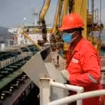 A PDVSA oil worker performing a maneuver to load/unload a shipment from an Iranian tanker in 2020 at the El Palito Refinery in Carabobo state, Venezuela. Photo: AFP/Getty Images/file photo.