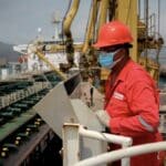 A PDVSA oil worker performing a maneuver to load/unload a shipment from an Iranian tanker in 2020 at the El Palito Refinery in Carabobo state, Venezuela. Photo: AFP/Getty Images/file photo.