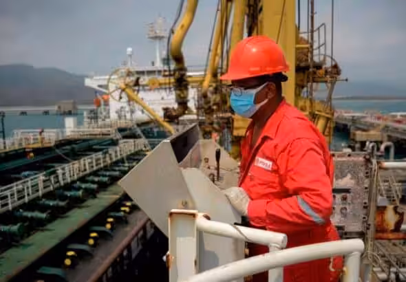 A PDVSA oil worker performing a maneuver to load/unload a shipment from an Iranian tanker in 2020 at the El Palito Refinery in Carabobo state, Venezuela. Photo: AFP/Getty Images/file photo.